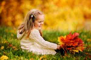 Kind in Herbstlaub