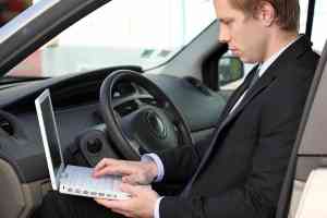 Mann mit Laptop im Auto