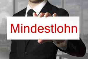 © Imillian - Fotolia.com Geschäftsmann hält Schild Mindestlohn