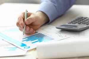 Person zeigt mit Stift auf Akten