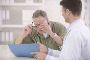 © mangostock - Fotolia.com Arzt zeigt Patient Akte