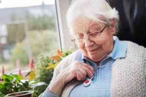 Alte Frau mit Notknopf
