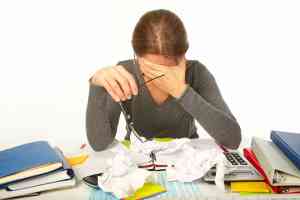 © Petrik - fotolia.com Frau verzweifelt am Schreibtisch
