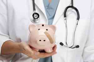 © Andy Dean - fotolia.com Arzt hält Sparschwein