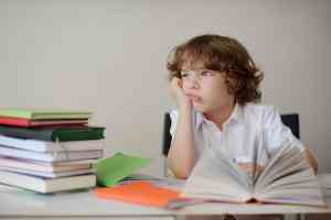 © unguryanu - fotolia.com Junge sitzt am Schreibtisch