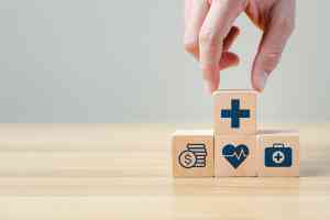 Hand legt einen Holzblock auf andere Blöcke