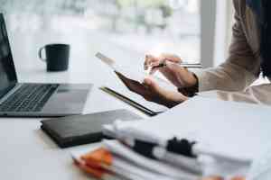 © itchaznong - stock.adobe.com Person mit Taschenrechner